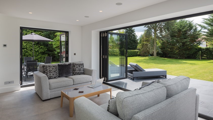 Anthracite aluminium bifold doors open onto a garden in Marlborough